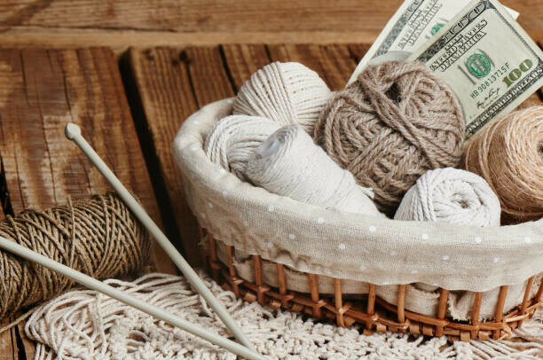 How To Choose Profitable Affiliate Niches image 5 balls of wool with knitting needles with dollar bills showing how hobbies can become a profitable niche make xtra money online