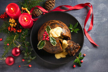 Christmas Pudding But Not As Youd Expect image 2 christmas pudding topped with holly leaves christmas decorations surrounding and brandy butter topping frosted fusions