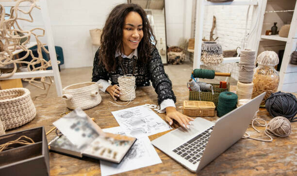How To Choose Profitable Affiliate Niches image 3 woman at desk with wools string and twines surrounding her as she works on laptop make xtra money online