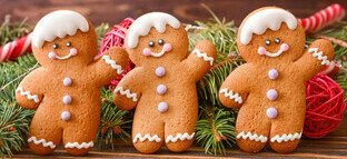 Spice up the Season Festive Homemade Gingerbread Ice Cream image 2 three gingerbread men decorated and waving with christmas tree decorations in background frosted fusions