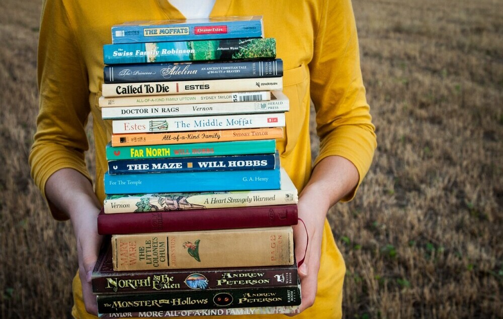 Lady holding a stack of books 