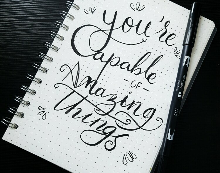 A notebook with the writing - you are capable of amazing things - written on it