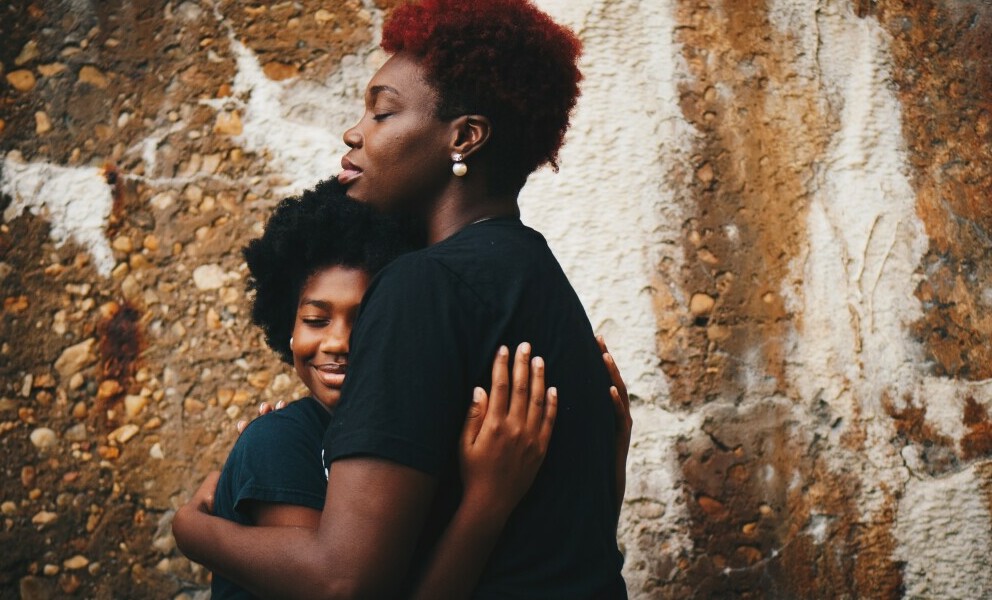 Two african american girls hugging