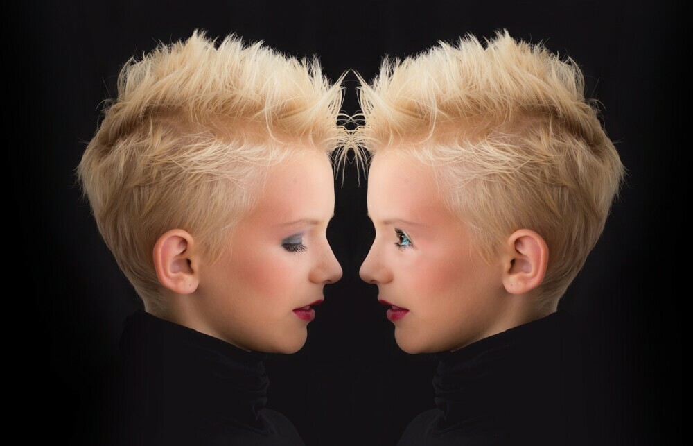 Girl looking at reflection where one image has eyes looking down and the other eyes looking at the other image