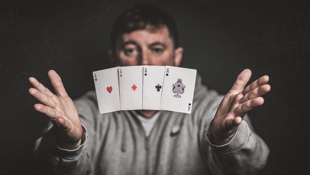 Ametuer magician showing a card trick with floating aces 