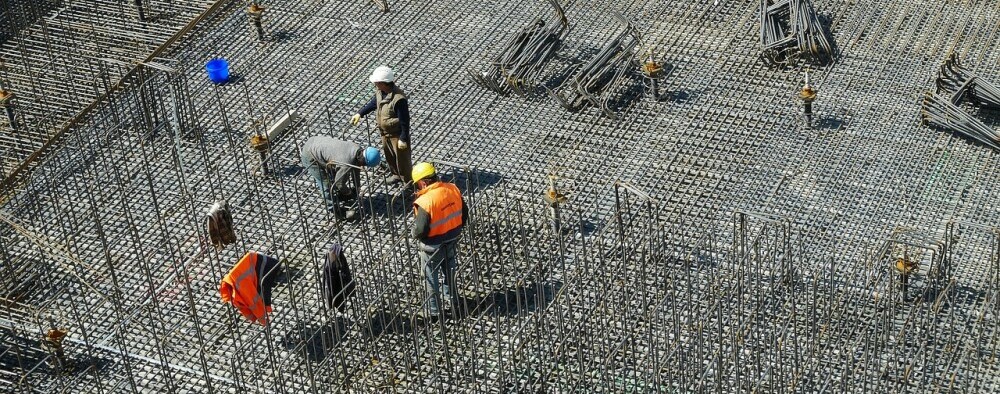 Construcion workers laying the groundwork for building upon.