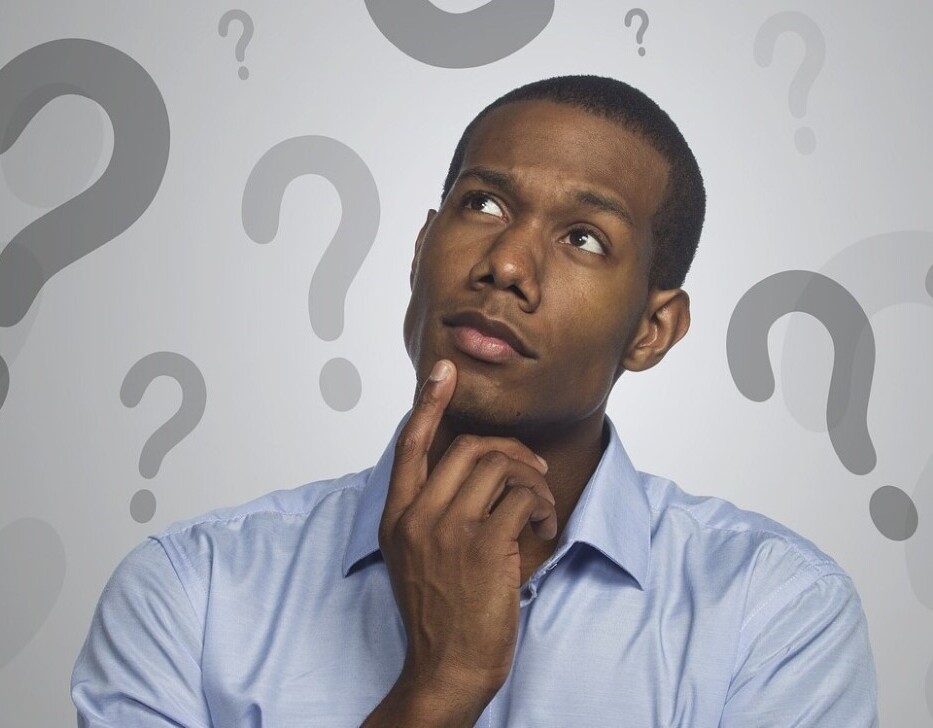 picture of black man with question marks around him pondering how to solve sliding tile puzzle