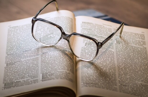 Open book with eyeglasses on it