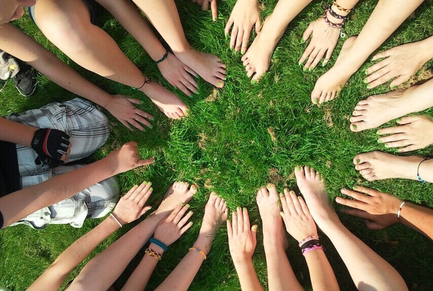 circle of hands reaching into the middle