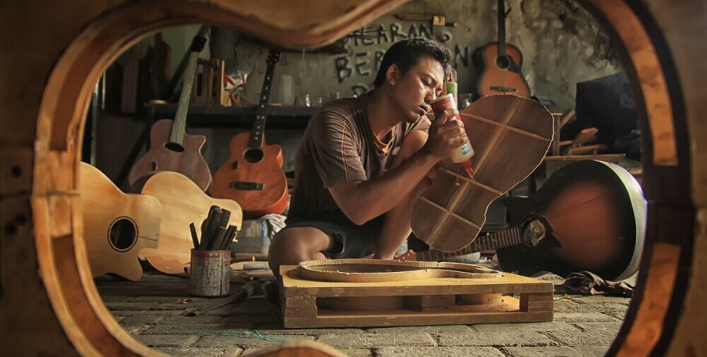 a man engaging in a creative hobby of building guitars