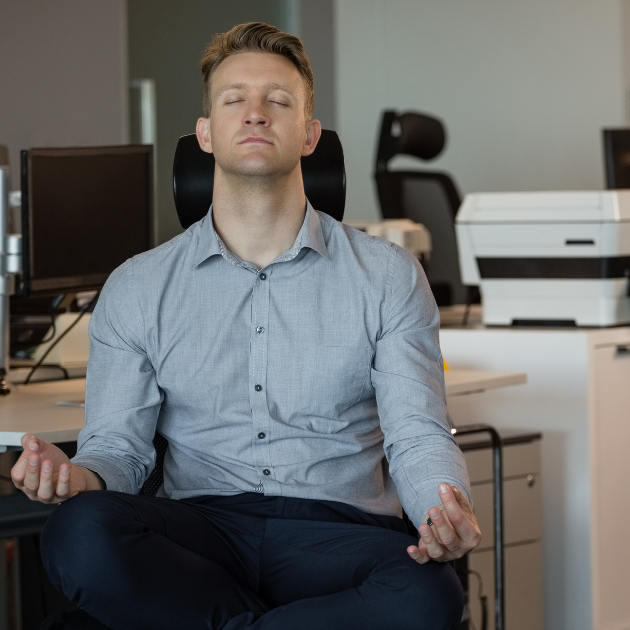 A man doing a deep breathing exercise before an important presentation at work.