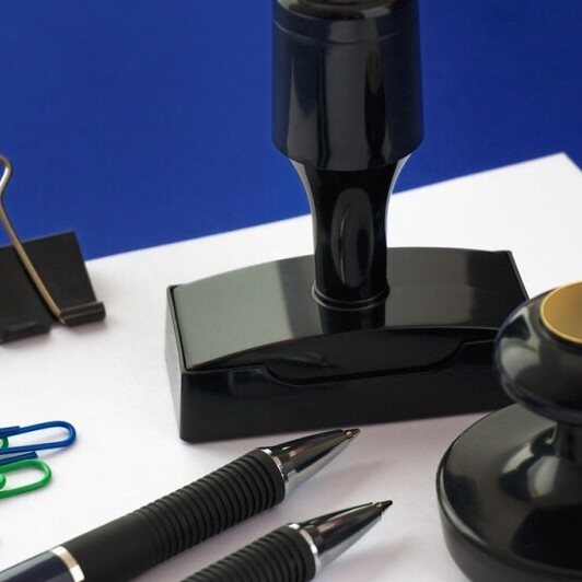 stamps and pens with clips and paper