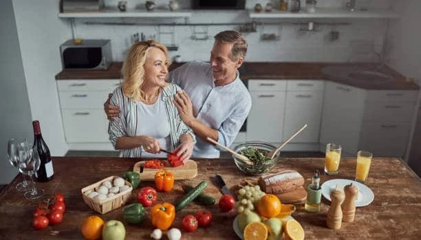 Family preparing a healthy homemade meal together in a modern kitchen with fresh vegetables and ingredients.