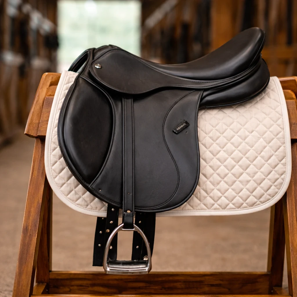 collegiate degree dressage saddle on wooden rack