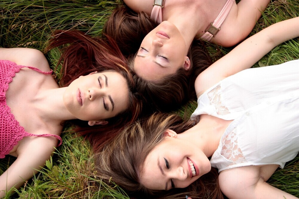 3 happy women lying on the grass