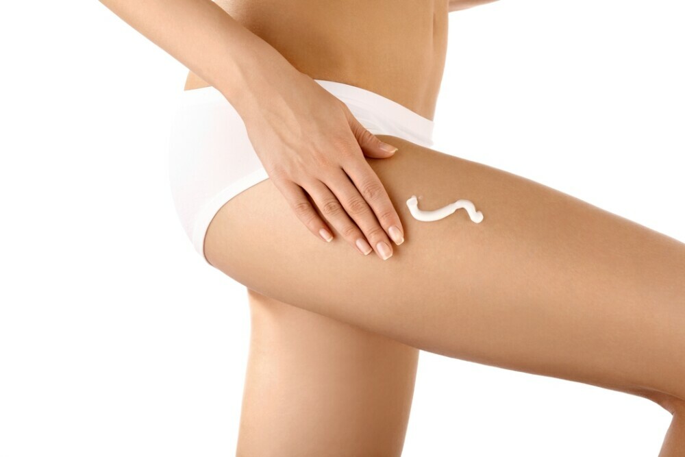 a woman applying cream on her legs