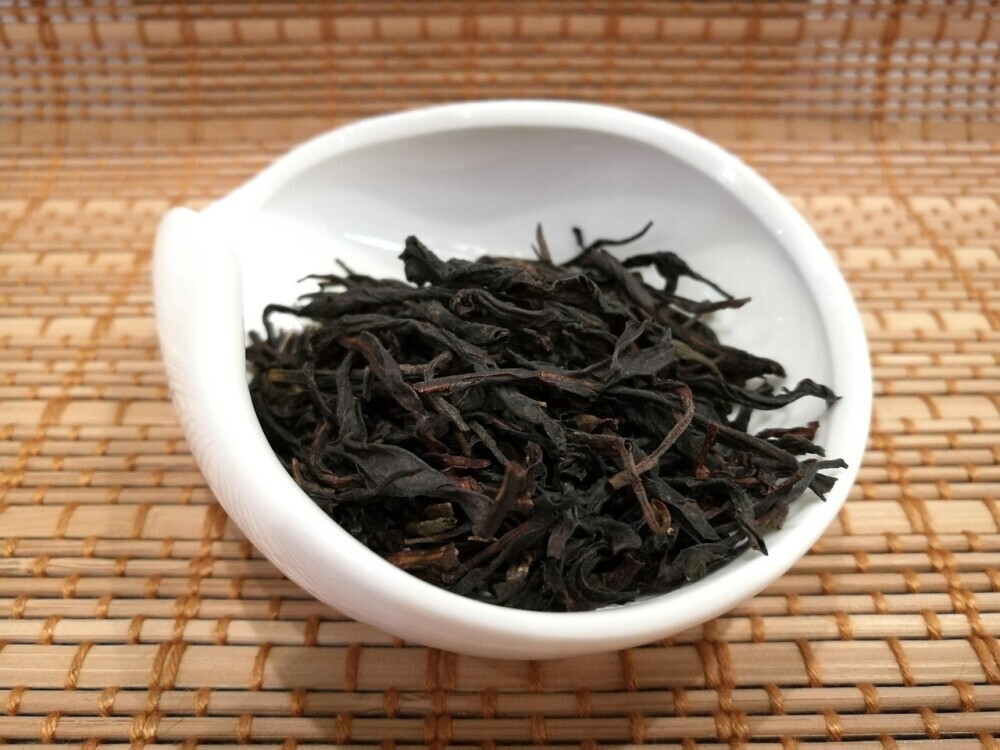 Dan Cong Oolong tea leaves in white bowl on bamboo mat