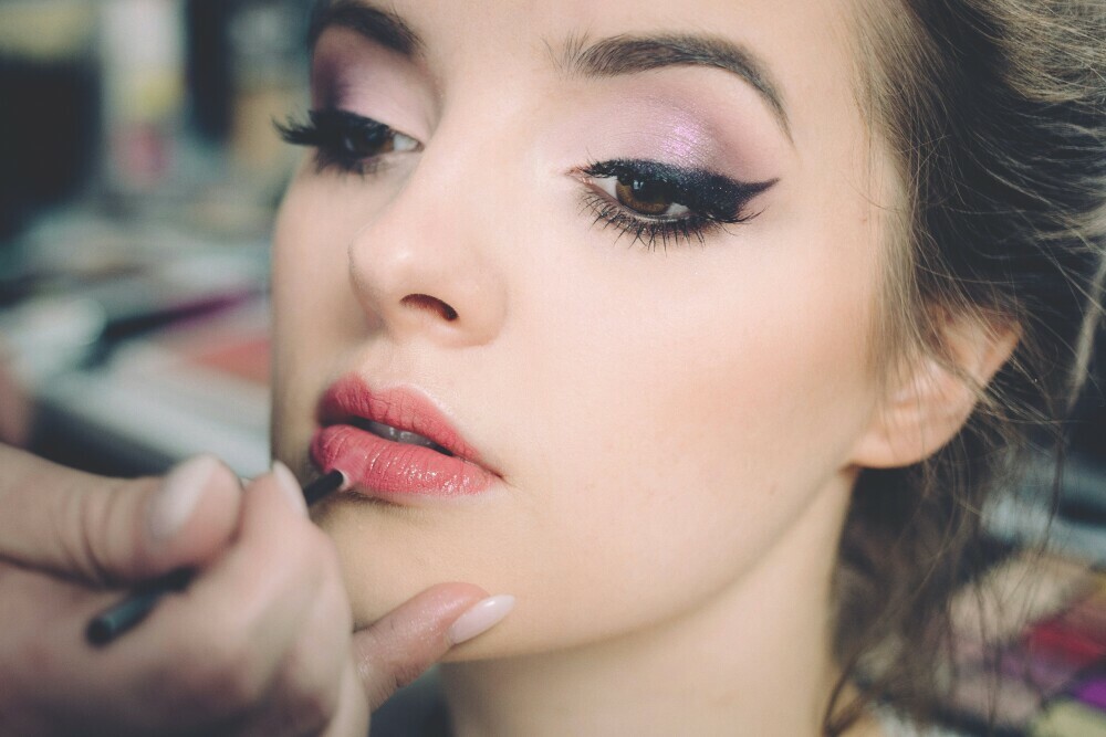 a woman applying makeup on face