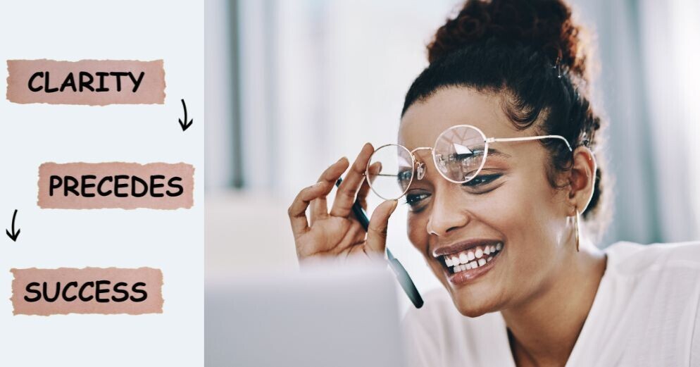 The image has three words on the left that read Clarity precedes success,  and on right (beside the text) is a photo of a woman smiling while raising her eyeglasses slightly while looking happily a laptop screen giving the impression whatever is on it, is engaging on an emotional level.